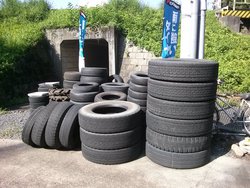屋外に置かれた沢山のタイヤの写真