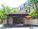 日光 星の宿の本館をバックに和風の門構えと緑の木々がある入り口を写した写真