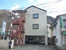 鉄筋の外階段がある3階建てで1階が駐車場になっているロマン新館つつじ店外観全体を写した写真
