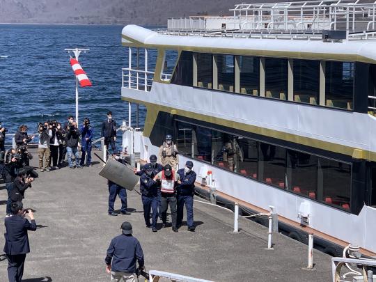 立木観音遊覧船発着所で犯人役の男性が警察の方々に捕まり連行されている訓練の様子の写真