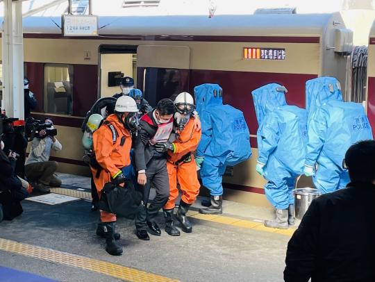 東武日光駅で要救助者役の男性が消防隊員の方々に救助されている訓練の様子の写真