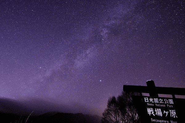 日光国立公園戦場ケ原の案内板の奥に広がる天の川を写した写真