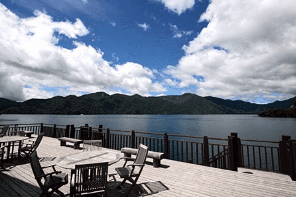 中禅寺湖畔ボートハウスから見える湖と青い空と白い雲の写真