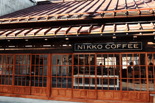 朱色の格子型の入り口上部にNIKKOCOFFEEの看板が飾られた日光珈琲の入口写真