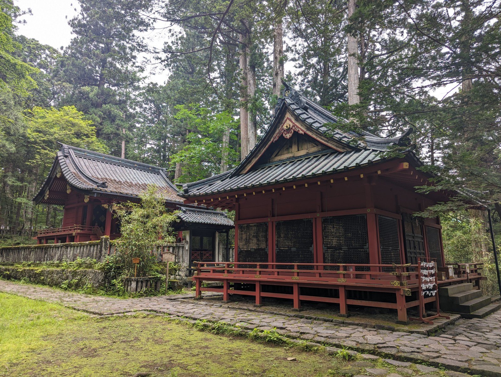 屋根が黒で全体が朱塗りの滝尾神社を写した写真