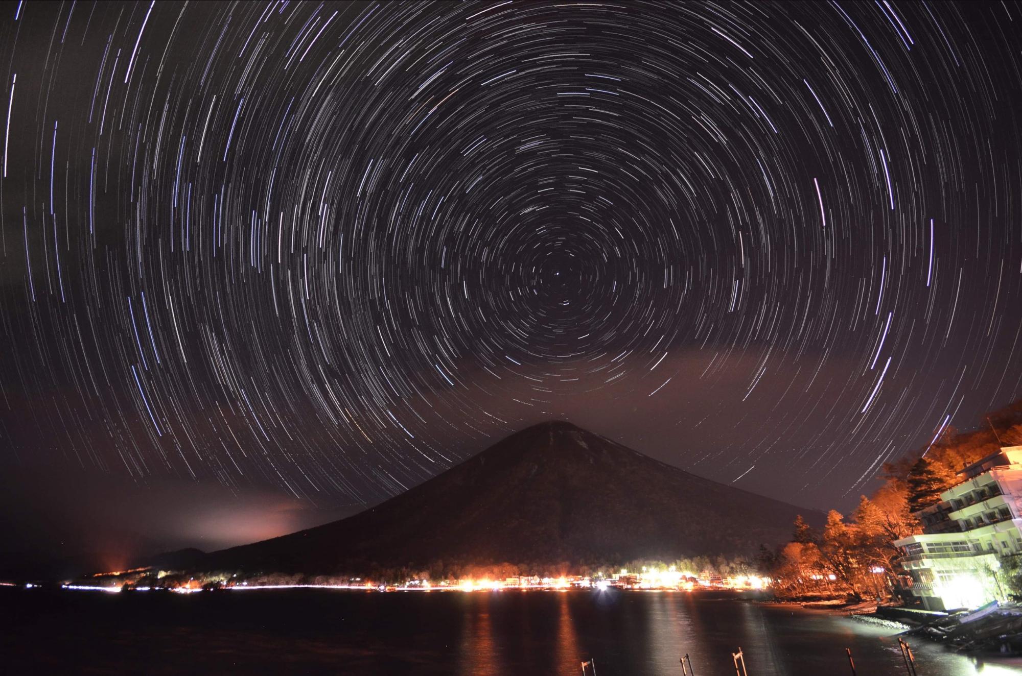 男体山の周りに円を描いたように見える星空を写した写真