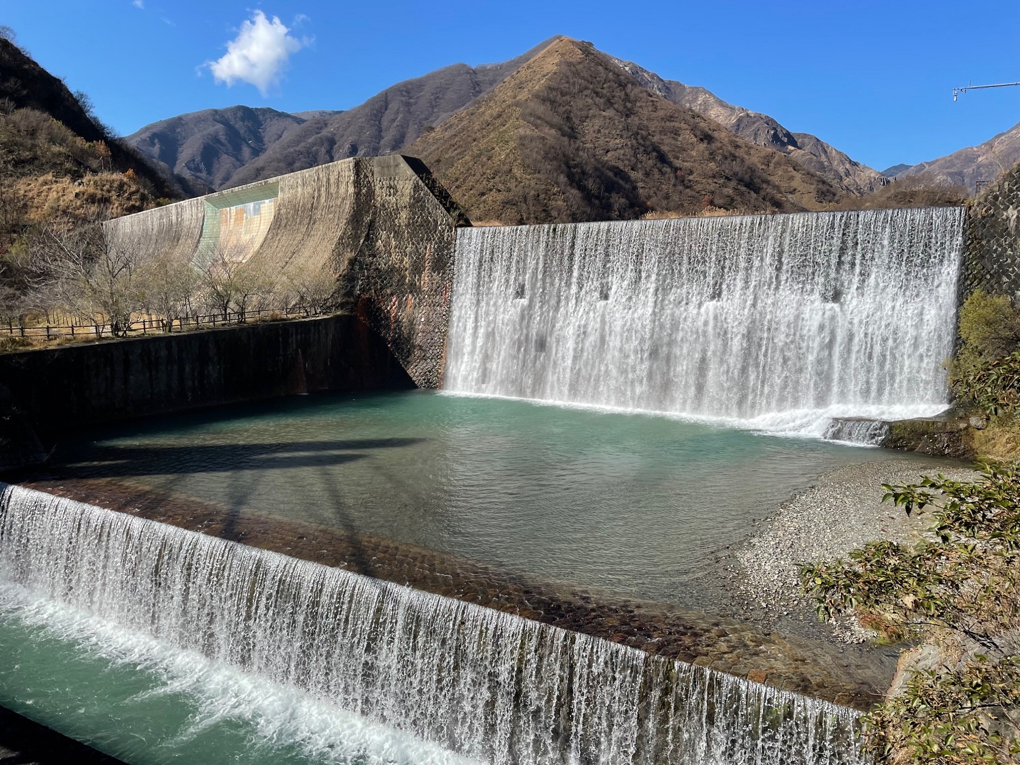 銅親水公園内の砂防ダムとその奥にそびえる山々を写した写真