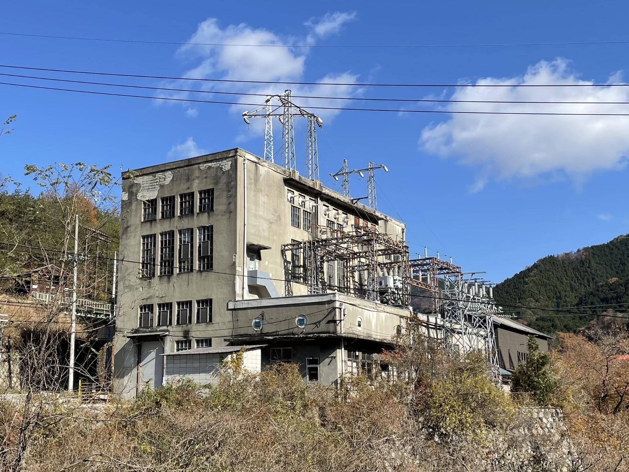 青空に浮かぶ白い雲の下に建つ昔ながらの通洞変電所の建物外観を写した写真