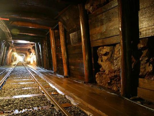 足尾銅山内に線路があり、木の柱で覆われている写真