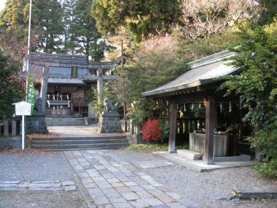 古い手水所と鳥居に続く参道の写真