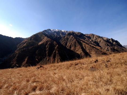 緑がなく茶色い色をした、山と平原の写真