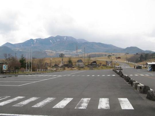 雄大な山々と広い駐車場の写真