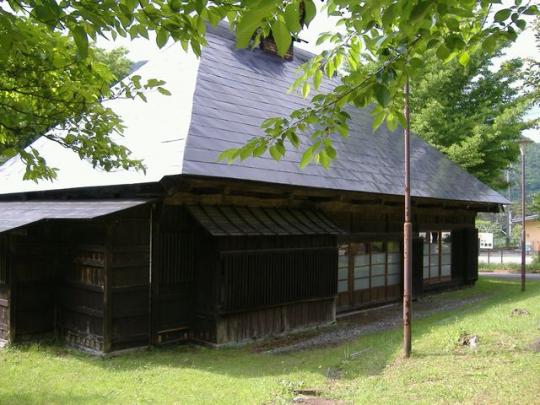 芝生に囲まれた古い民家のような建物の写真