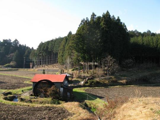 畑の中にある水車小屋の写真