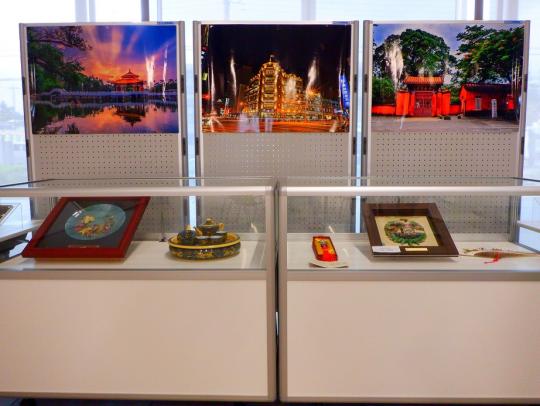 3枚の風景写真と2個のガラスのショーケースに展示された物を正面から写した写真