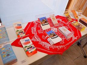 長机の赤い布の上にいろいろなガイドブックが並べられている写真