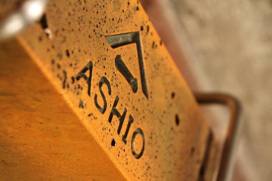 「ASHIO」と書かれている四角く茶色い塊の銅の写真