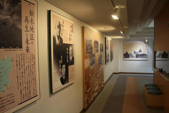 説明文が書かれたパネルが壁に展示されており、展示スペース前には腰かけ椅子が置かれている館内の写真