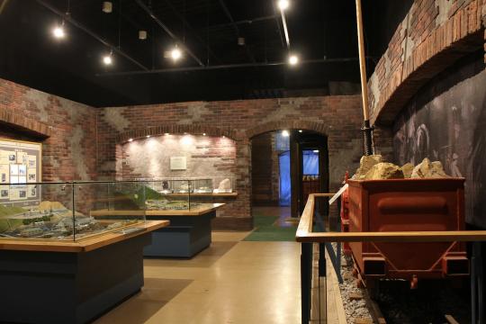 レンガの壁で作られた部屋の、足尾銅山の模型や、トロッコ、写真などが展示されている写真