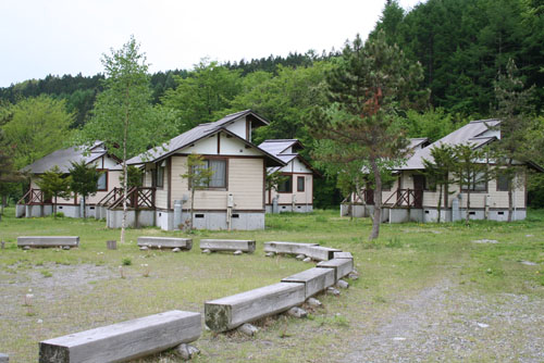 ケビンが建ち、木製のベンチが並んでいる写真