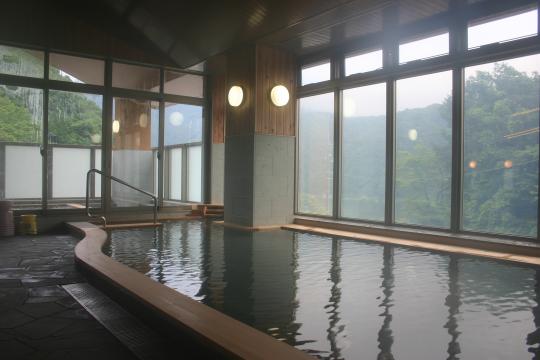 壁面全体が窓になっている広々とした大浴場の写真