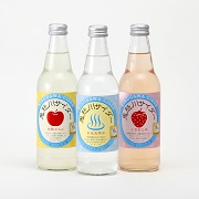 透明な瓶に入ったりんご味やイチゴ味の3種類の鬼怒川サイダーの写真