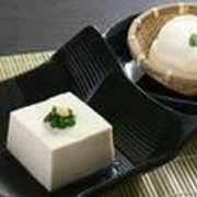 お皿にネギとショウガの添えられた豆腐とザル豆腐の松葉屋の手造り豆腐の写真