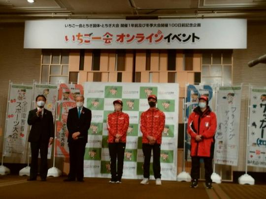 市長がマイクを持ち挨拶をする横に関係者が4人並んでいる国体いちご一会オンラインイベントの様子の写真