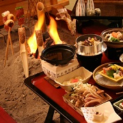 囲炉裏で川魚や山の幸が炙られ、土鍋や釜飯などの料理が並んだ栗山地域の囲炉裏料理の写真
