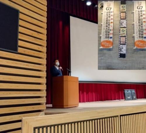 日光シネマ会場の舞台の演壇で挨拶をする市長を横から撮影した写真