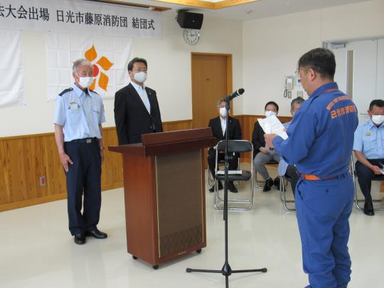 藤原消防団の方が挨拶され向かい合って市長と男性が立っている藤原消防団操法大会結団式の様子の写真