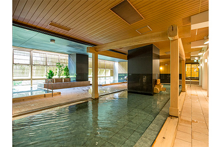 木造りの大きな浴槽のある鬼怒川温泉ホテルの写真