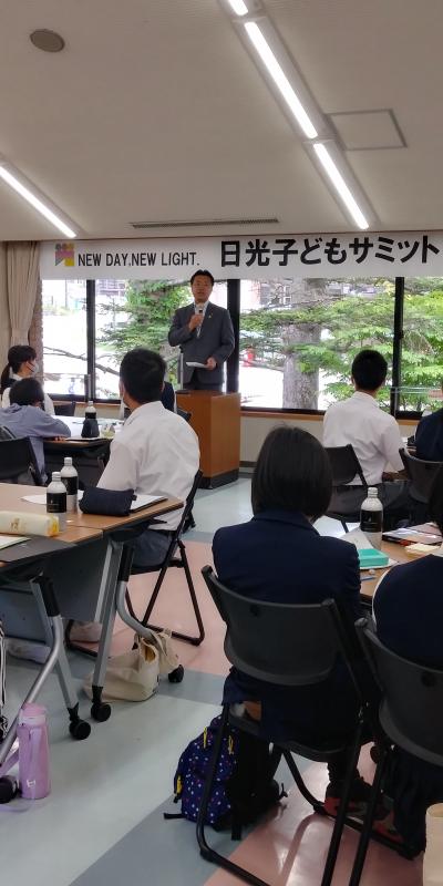 演壇で市長が話をするのを子供たちが聞いている子どもサミットの様子の写真