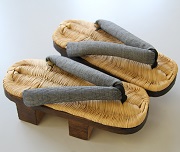 竹の皮で編んだ草履表を麻糸で縫い付けてあり、鼻緒がグレーの日光下駄の写真