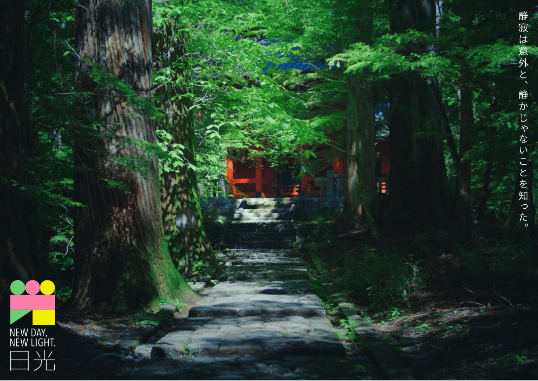 「静寂は意外と、静かじゃないことを知った。」の文字と、大きな木々が並び、緑の葉の奥に神社が見えている写真