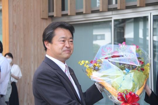 初当選した粉川昭一市長が花束を受け取り笑顔で初登庁している様子を写した写真