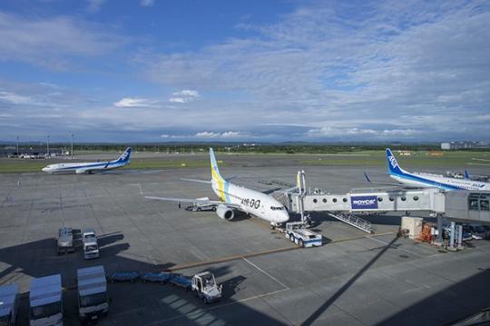青空の広がる空と3機の飛行機が停まっている新千歳空港の様子の写真