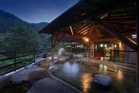 山の風景が見える露天風呂のある鬼怒川温泉ホテルサンシャイン鬼怒川の写真