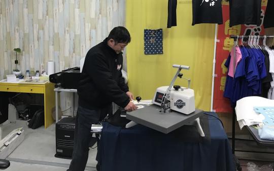 店内の機械を操作する黒い服を着た男性の写真
