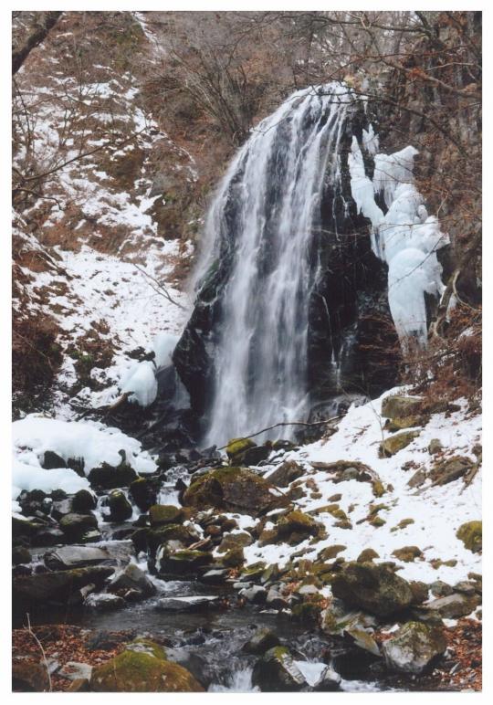 雪の積もる山肌を流れ落ちる相生滝の写真