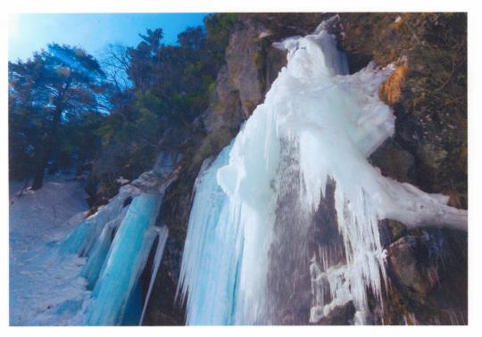雪山の中、多数のつららの様に凍てついた庵滝の写真