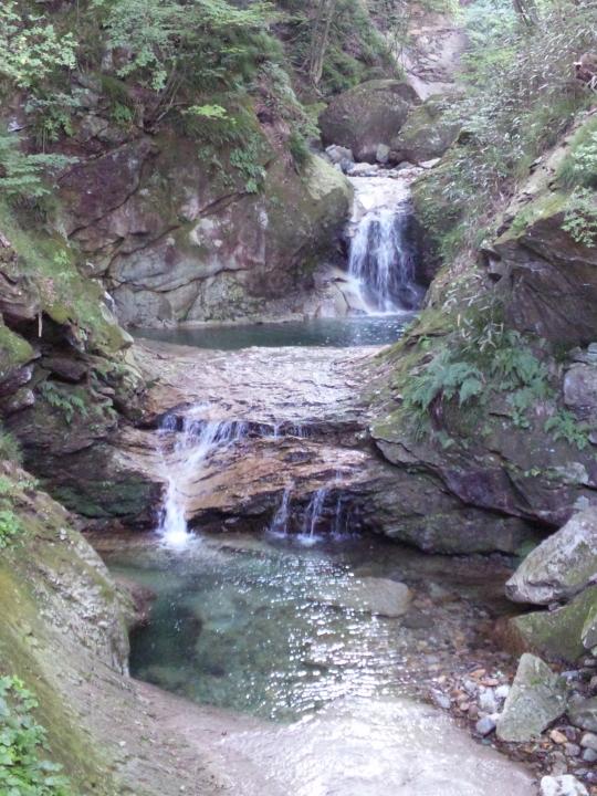 岩の表面を壇上に流れ落ちる古釜沢の滝の写真