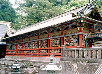 極彩色が施された回廊に彫刻が彫られ、石の土台の上に建っている東照宮東西回廊の写真