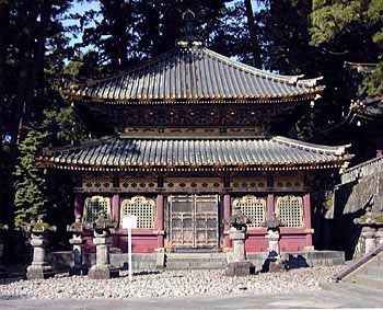 5基の石灯籠の後ろに建っている重曹方形造、一重もこし付の建物で、全体が朱色、格子状の窓に金色の装飾などが見られる東照宮経蔵の写真