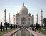 まっすぐに伸びた泉水の先に建っている左右対称に作られた白いタージ・マハル（インド）の写真
