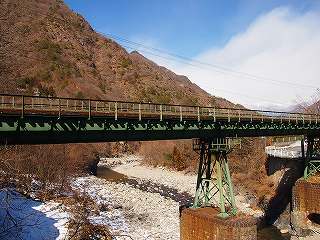 山が見える手前に架かっている足尾鉄道第一松木川橋梁の写真