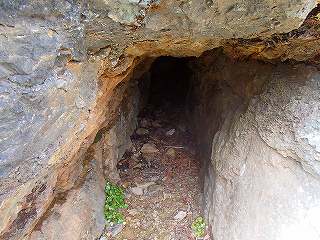人1人通れる程の幅で奥へと坑道が続いている近世の坑道跡（狸掘といわれる）の写真