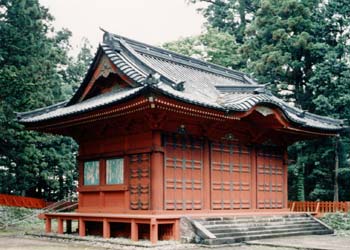 建物正面側に石階段が設置され、全体が朱色で入母屋造の御旅所本殿（おたびしょほんでん）を斜めから写した写真