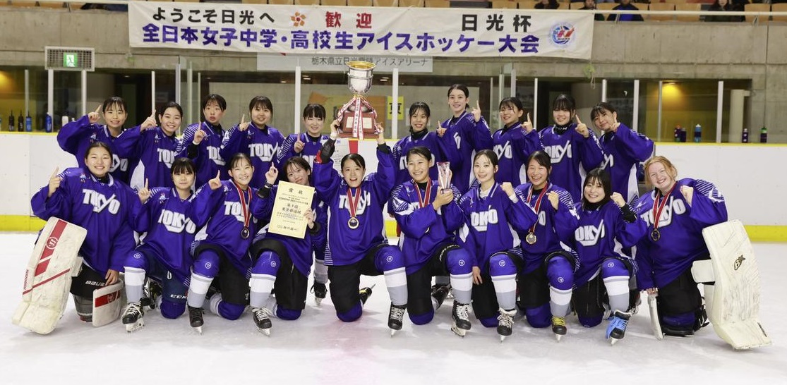 トロフィーと表彰状を持ち金メダルをつけている女子ホッケーチームの集合写真