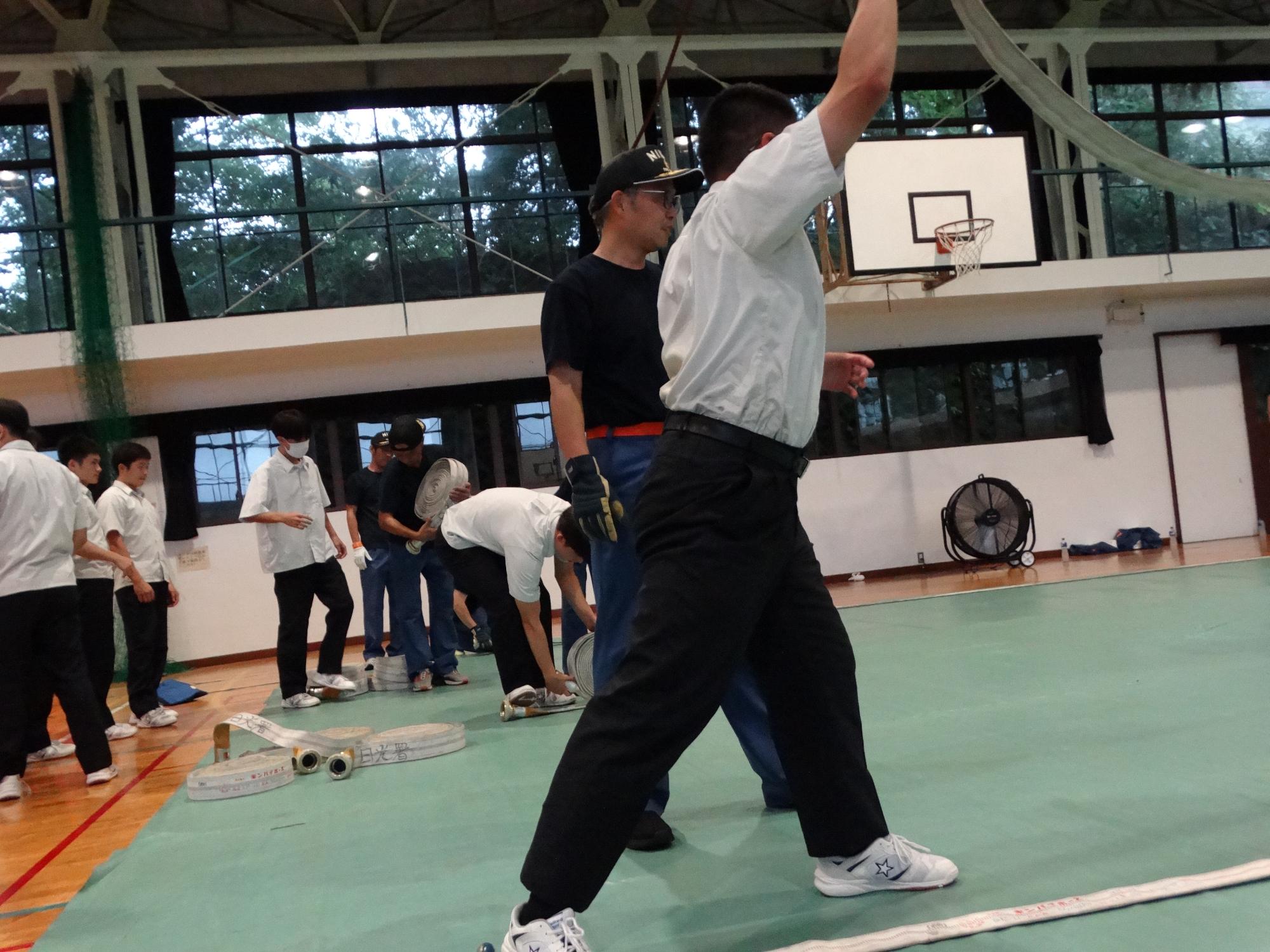 ホース展張要領を指導している消防団員